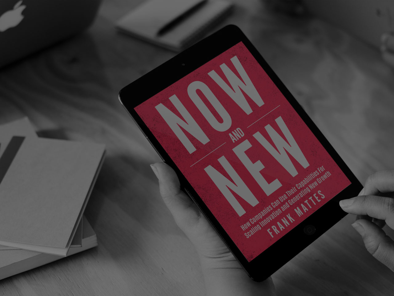 Person holding a tablet displaying the book cover of 'Now and New' by Frank Mattes, focused on scaling innovation and generating new growth.